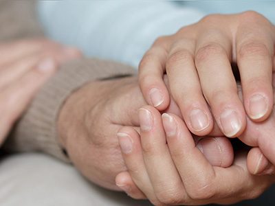 Hands holding during a tough time.